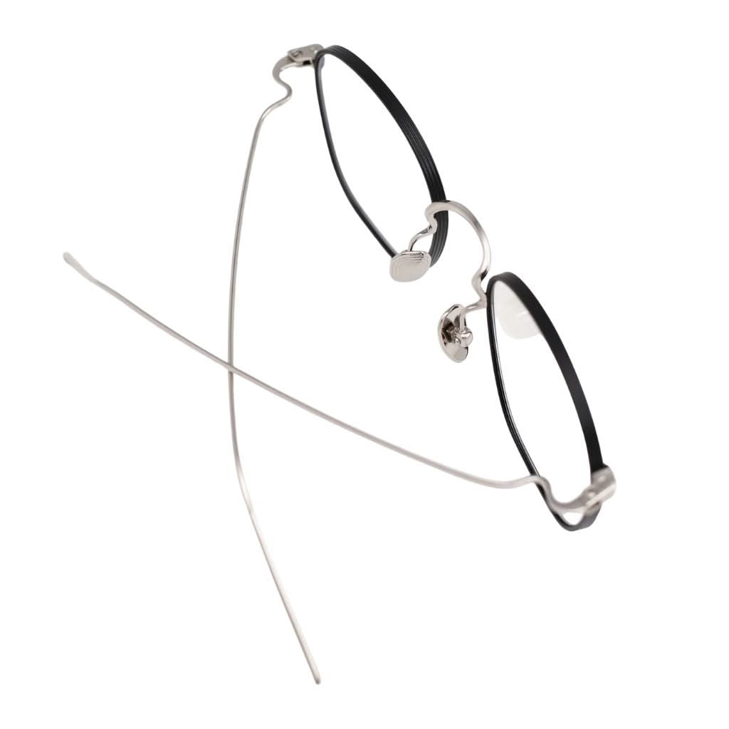 Detailansicht der AKILA Osiris 02 – feine Titanverarbeitung in Schwarz und Silber, minimalistische Designerbrille bei Optik Bartholomä München