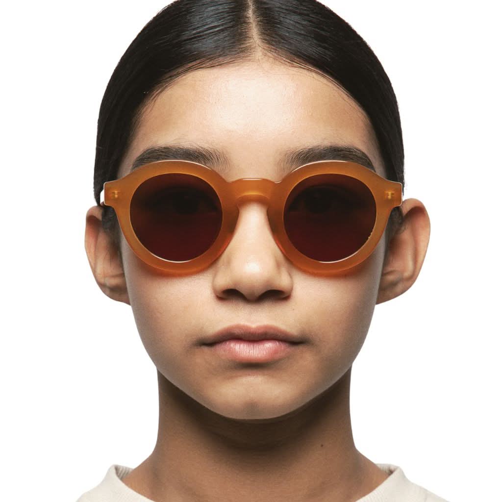 Kind trägt die Kaleos Kids WAIALIKI col. 3 Sonnenbrille in Braun – erhältlich bei Brillen Schneider in München.