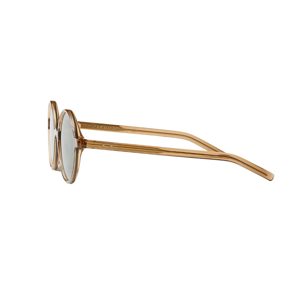 Die IRIS SUN Sonnenbrille in der exklusiven Farbe Crystal Caramel von Oscar Magnuson. Ideal für jeden Anlass, erhältlich bei Brillen Schneider in München